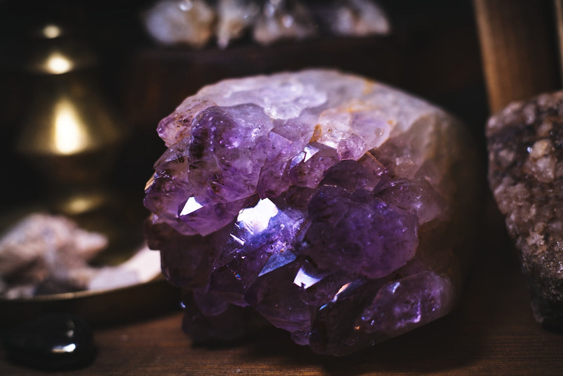 A cluster of purple crystals sitting on top of a wooden table